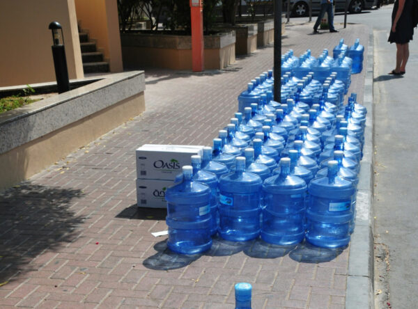 viele blaue Plastikkanister voll Wasser nebeneinander aufgestellt